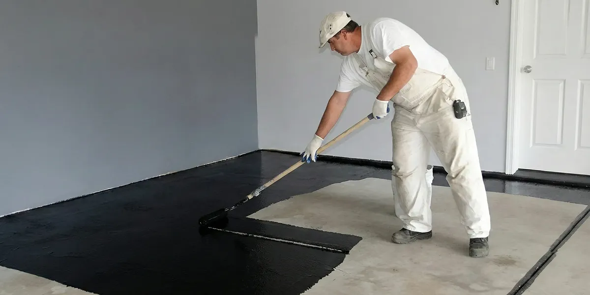 basement waterproofing professional applying waterproof coating to protect a basement floor in Ogden, UT